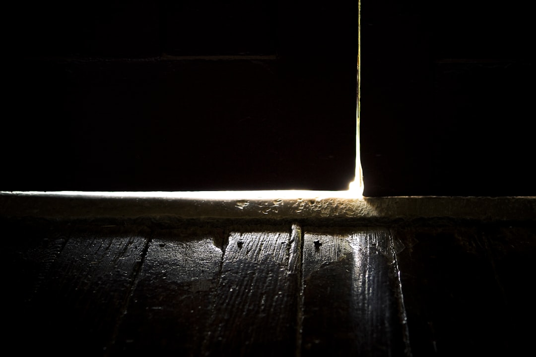 A powerful, focused beam of light from a tall lighthouse cuts through the deep darkness of night over the ocean, representing a clear revenue signal piercing through digital noise.
