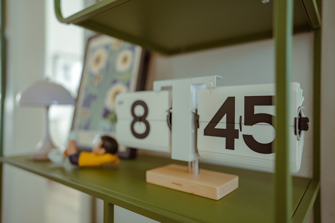 A sleek, modern hourglass on a clean office desk with the sand nearly empty in the top bulb, illustrating the hidden financial cost of wasted time.