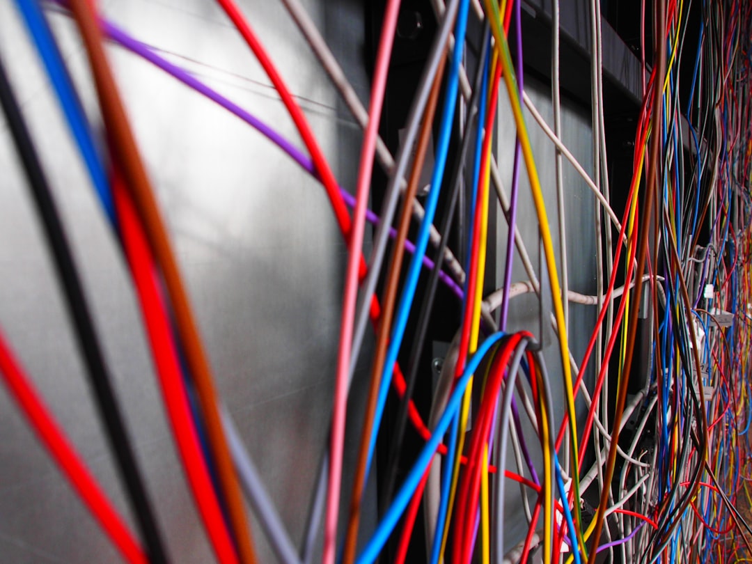 Brightly glowing blue and purple network cables plugged into a server rack, symbolizing the rapid and secure flow of data in a verifiable supply chain.