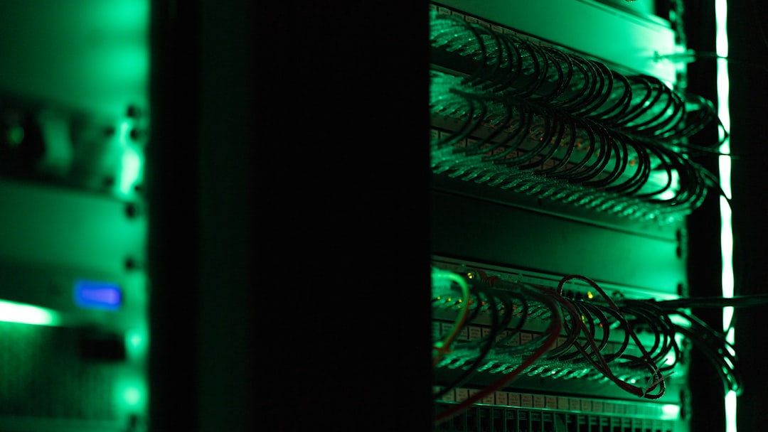 A close-up of a tangled mess of colorful network cables plugged into a server rack, illustrating technical complexity and drag.