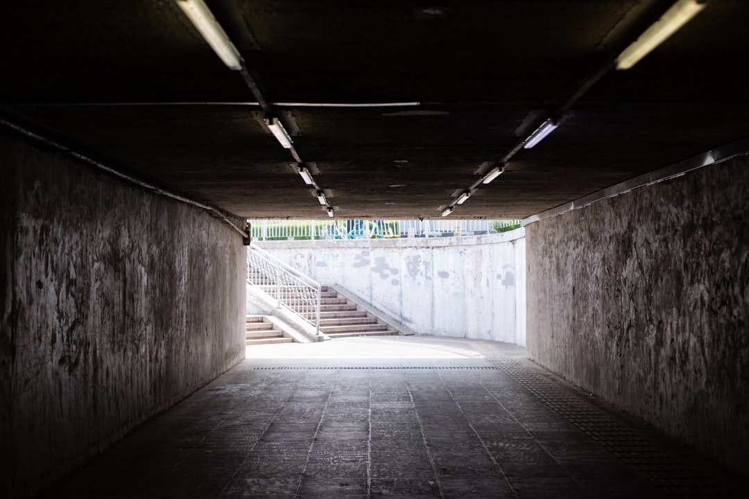 A dramatic shot of a single beam of light shining through a crack in a dark, minimalist concrete wall, representing a hidden, critical flaw in a system.