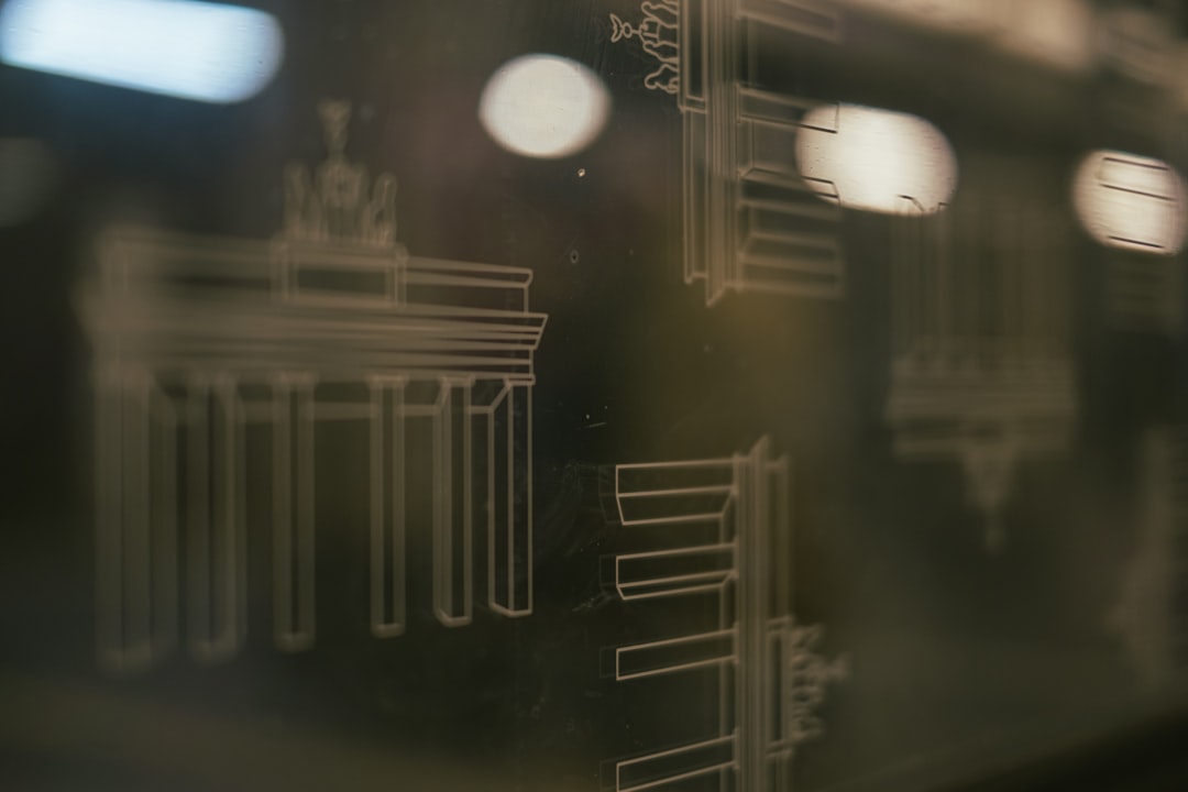 A professional in a modern office uses a marker to draw a complex flowchart on a transparent glass wall, symbolizing strategic planning and creating a protocol.