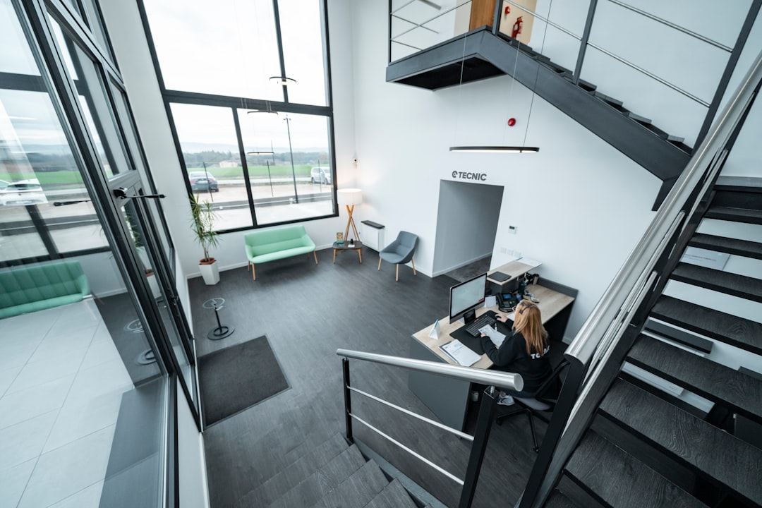 A CTO in a modern, bright office examining complex architectural blueprints, illustrating a strategic audit of digital infrastructure for SEO.