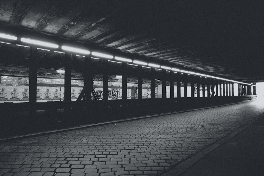Long exposure shot of straight light trails moving through a dark, modern tunnel, symbolizing a fast and direct path to information.