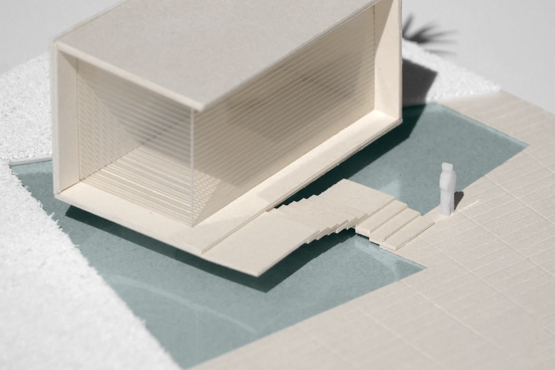 A meticulously crafted architectural model of a modern building on a clean, bright desk, representing the structured financial modeling of digital brand infrastructure.