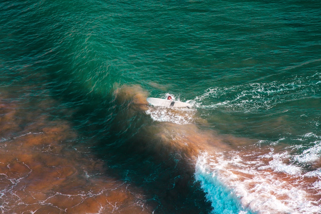 A small, agile boat expertly navigating a massive, powerful ocean wave, representing a 'giant killer' framework overcoming market challenges.