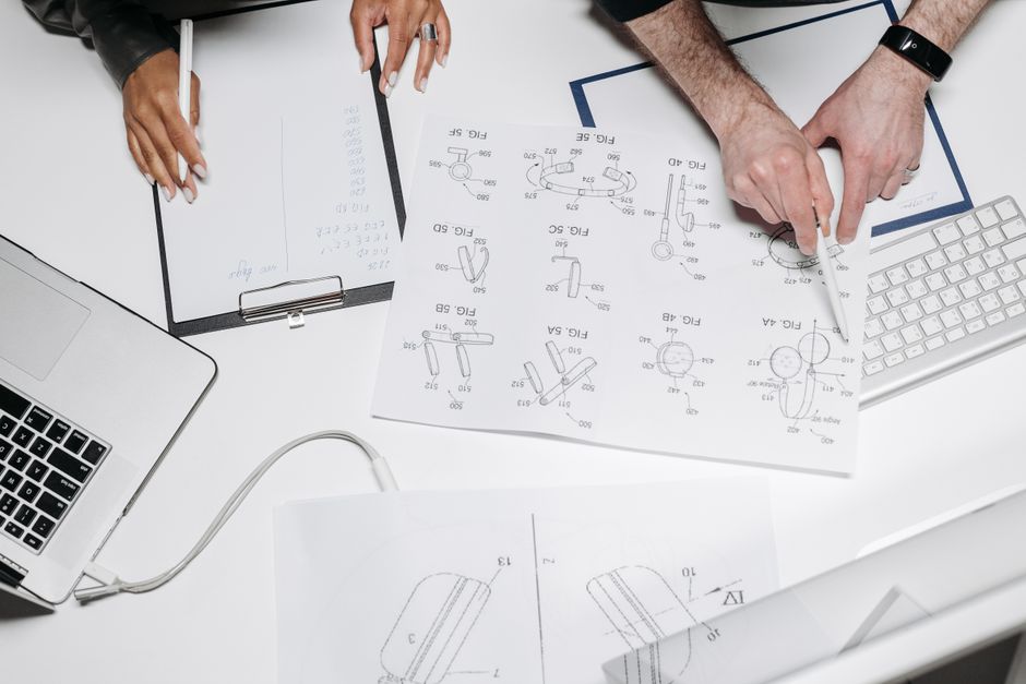 A focused technology professional in a bright, modern office drawing a complex data-flow diagram on a large glass wall, illustrating strategic planning and a CTO's protocol.