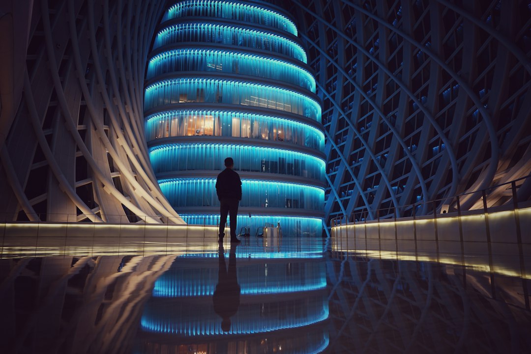 A lone individual stands before a massive, complex modern building, representing a small, agile protocol tackling a giant martech challenge.