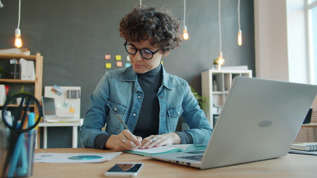 A professional architect in a modern, well-lit office carefully reviewing detailed blueprints on a desk, representing a framework for modeling infrastructure decay.