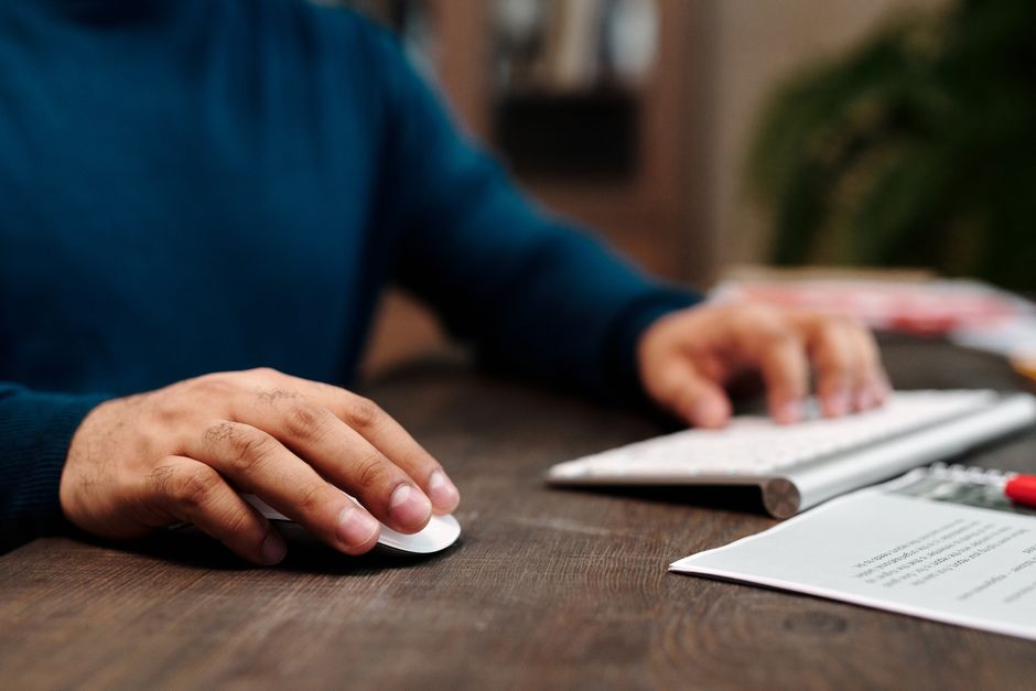 A close-up of a hand using a sleek computer mouse on a clean, minimalist desk, symbolizing one-click efficiency and digital solutions.