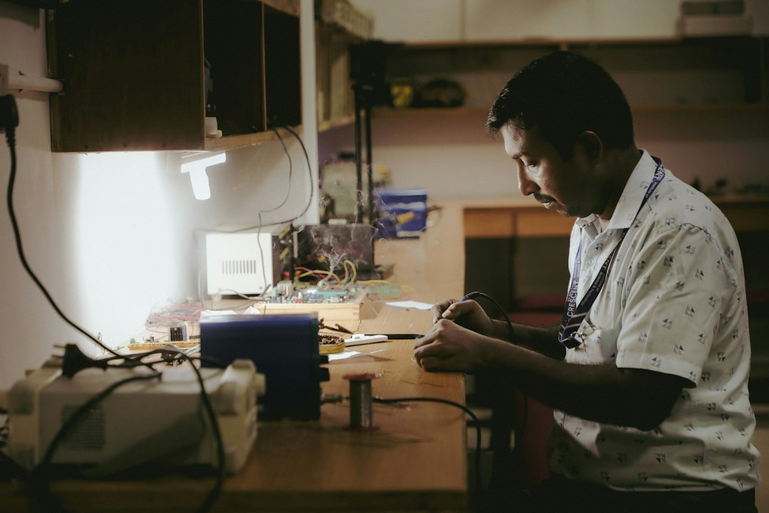A focused engineer meticulously examining a complex circuit board in a bright, modern lab, illustrating the diagnostic process of identifying technical debt.